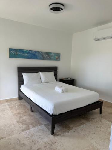 马纳蒂Manati World Point Inn的一间卧室配有一张带白色床单的大床