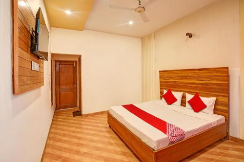 BanūrSuper OYO Hotel NR Residency的一间卧室配有红色枕头的床