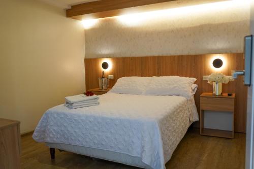 昆卡Grand Hotel Santa Ana的卧室配有白色的床和木制床头板