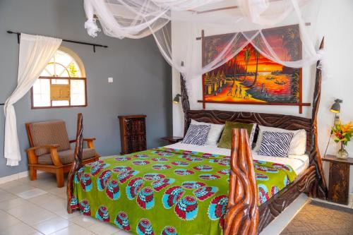 Sere KundaAfro Garden Hotel的卧室配有一张床,墙上挂有绘画作品