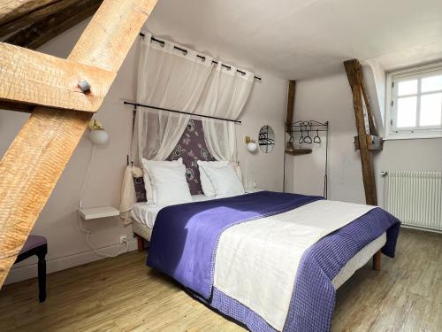 Savigné-sur-LathanCloserie la Fontaine的一间卧室配有一张带蓝色和白色棉被的床