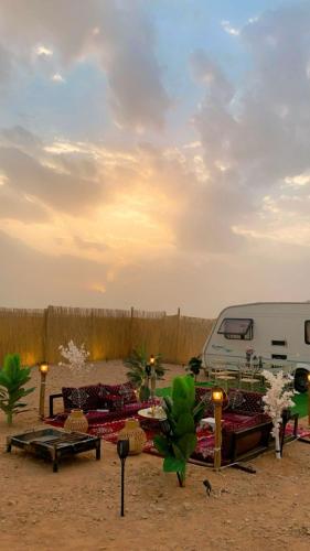 利雅德كرفان قمر الليل الملكي مع ضيافة vip的沙漠中的一张野餐桌,后面有一辆面包车