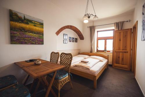 因德日赫城堡尤帕普斯克膳食公寓的卧室配有1张床、1张桌子和1张桌子以及椅子。