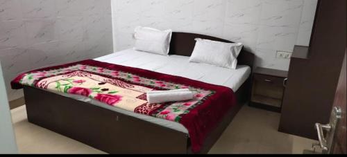 斋浦尔HOTEL BITTY KRISHNA的一张带毯子的床和两个枕头