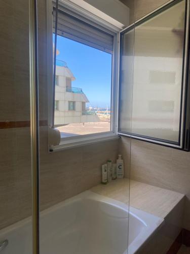 希洪Poniente Beach的带浴缸的浴室和窗户。