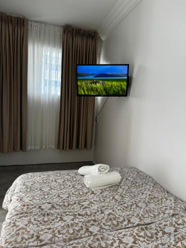 索维拉SIMI home的卧室配有一张壁挂式平面电视的床。