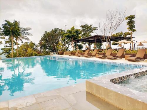 宿务Mabini Sky View Resort的一个带椅子和遮阳伞的大型游泳池