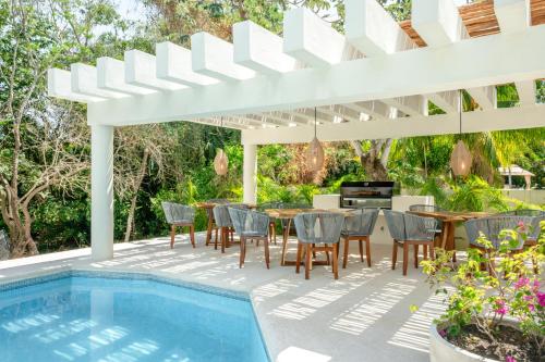 阿文图拉斯港Casa Manglar Riviera Maya的一个带桌椅的庭院和一个游泳池