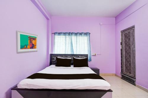 ĀsansolSPOT ON Hotel Sunshine Lodging的卧室设有紫色墙壁和1张床