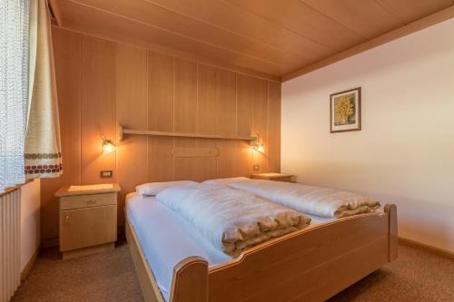 拉维拉DOLOMITdreams的一间卧室设有一张大床和两个床头柜