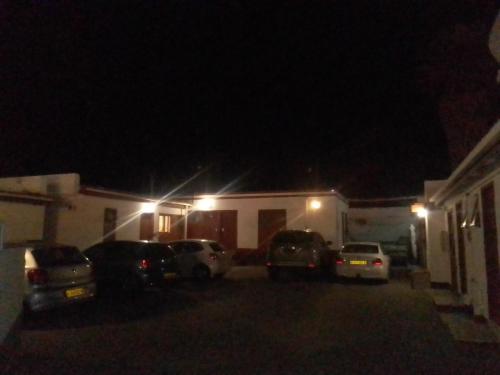 鲸湾港FEATHERS INN GUEST HOUSE的夜间房子前面的一个停车位