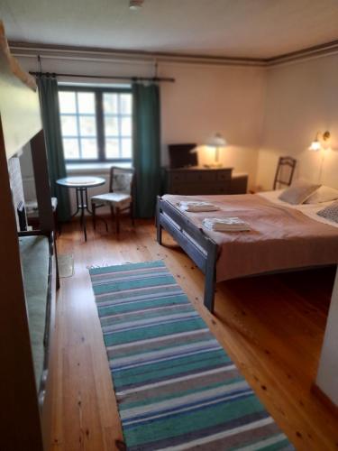维塔萨里Wiikki Majatalo的一间卧室配有一张床、一张桌子和一张地毯。