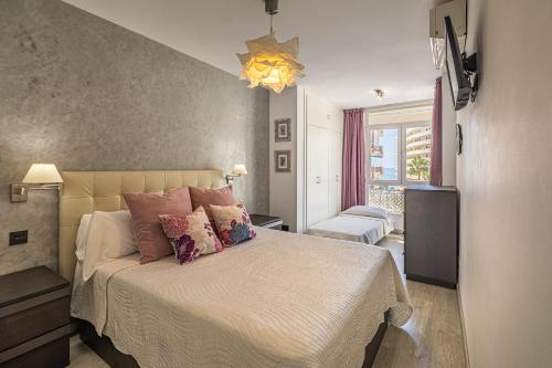 马贝拉City Center Apartment in Marbella的卧室配有一张带粉红色枕头的大床