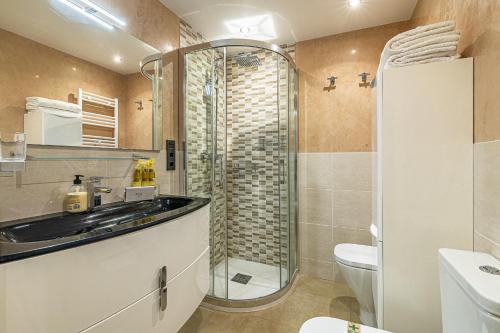 马贝拉City Center Apartment in Marbella的带淋浴和盥洗盆的浴室