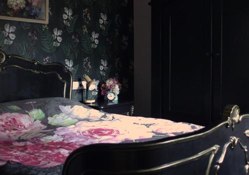 Stuifzand't Prentenhokkie的一间卧室配有一张带花卉毯子的床