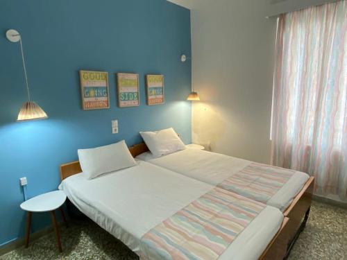 卡梅纳维洛拉Thalia Hotel的一间卧室设有一张蓝色墙壁的大床