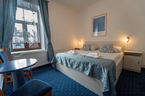 苏希采Hotel Gabreta的酒店客房设有床、桌子和窗户。