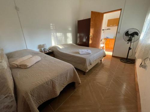 米纳斯Cómodo apartamento en Minas, con amplio fondo y entrada para vehículo的酒店客房配有两张床和风扇