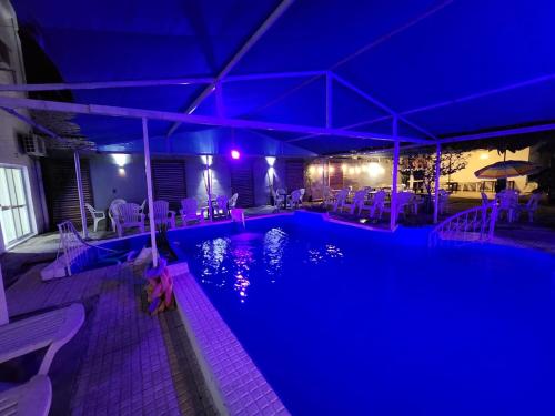 特尔马斯德里奥翁多Hotel Australia的游泳池在晚上点亮,紫色灯