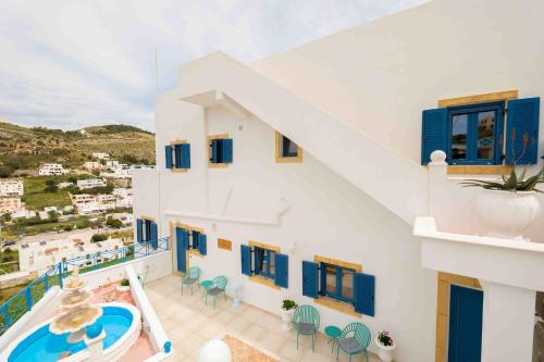 PanteliHELIADES SUITES的享有带蓝色窗户和游泳池的房屋景致