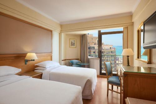 亚历山大蒙塔扎喜来登酒店的酒店客房设有两张床和一个阳台。