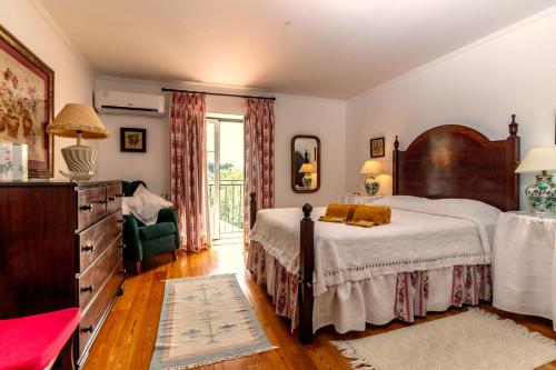 马尔旺Casa Do Ginjal by NaturAlegre的一间卧室配有一张大床和一个梳妆台