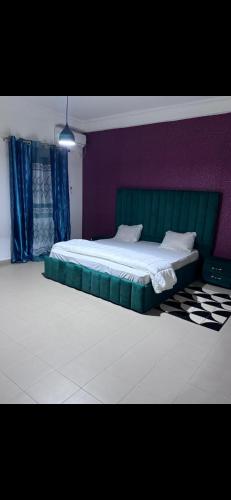 NgorJoli appartement ngor / Almadies的一间卧室配有一张绿色的床和紫色的墙壁