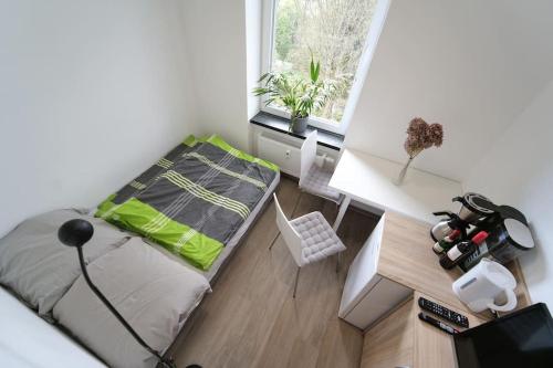 奥厄Preiswertes modernes Gästezimmer in Aue Bad-Schlema的一间卧室配有一张床、一张书桌和一个窗户。