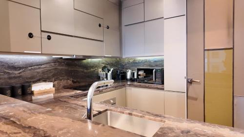 迪拜Damac Heights by Fendi的厨房配有白色橱柜和水槽