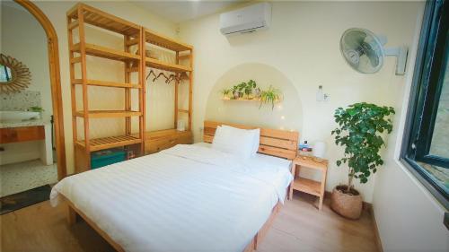 河内Dốc Chill - Villa gần Ba Vì, view núi, gần hồ, 40ph đi từ trung tâm Hà Nội的卧室配有白色的床和植物