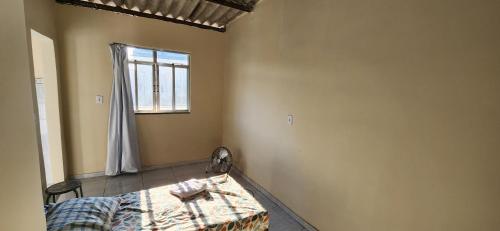 新伊瓜苏Kitinet aconchegante em Nova Iguaçu的一间卧室设有一张床和一个窗口