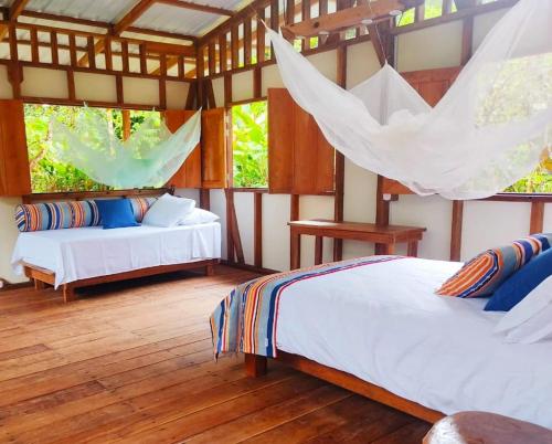 巴亚索拉诺Reserva Pakore Wera的一间卧室设有两张床和吊床。