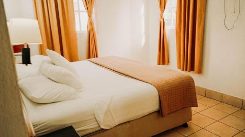 弗洛勒斯阿米莉亚卡萨酒店的一间卧室配有带白色床单和枕头的床。