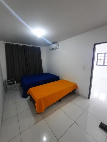德奥多鲁元帅镇Casa Buzios do Francês的一间设有一张蓝色和橙色毯子的床的房间