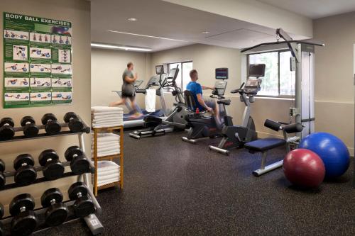 温哥华温哥华市中心假日套房酒店的两个男人在健身房锻炼举重