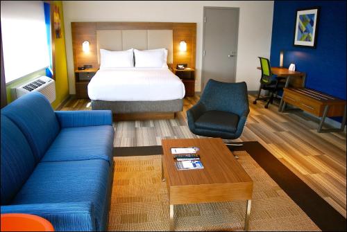 里士满里士满温哥华机场智选假日酒店的酒店客房,配有床和蓝色的沙发