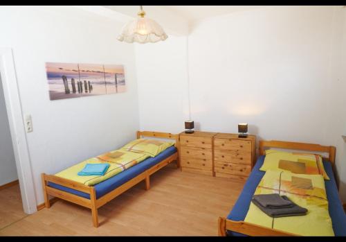 迈内尔茨哈根Schöne Unterkunft mit Billard的一间卧室配有两张单人床和一个梳妆台