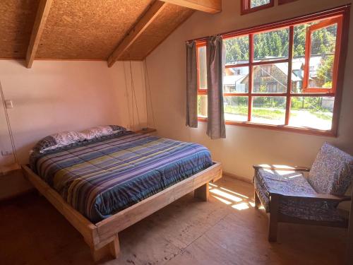 富塔莱乌富Mirlo’s hostel的卧室配有床、椅子和窗户。