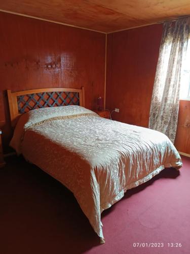 蒙特港Casa en Puerto Montt的一间卧室设有一张带木墙的大床