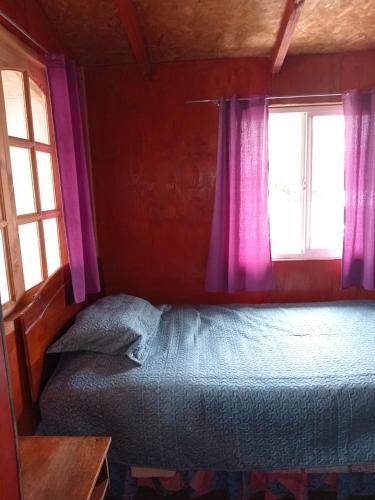 蒙特港Casa en Puerto Montt的一间卧室配有一张床,窗户配有紫色窗帘