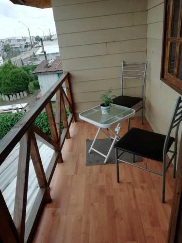 蒙特港Casa en Puerto Montt的小阳台,配有桌子和椅子