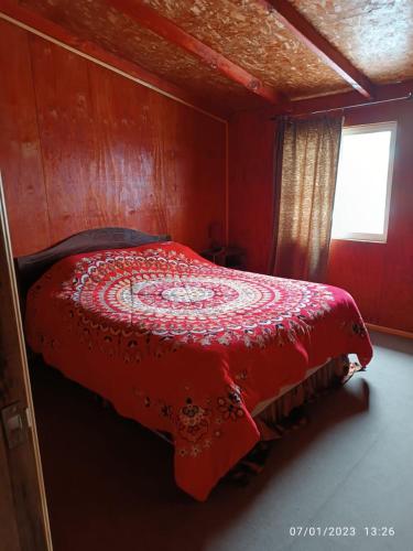 蒙特港Casa en Puerto Montt的窗户客房内的一张红色的床
