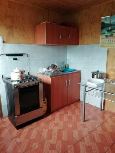 蒙特港Casa en Puerto Montt的厨房配有炉灶和桌子。