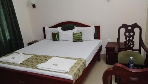 科钦Elim Homestay Fort Kochi的一间卧室,卧室内配有一张床和一把椅子