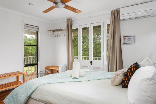 袋鼠谷Wild Rose Cottage Kiaroo Estate, Kangaroo Valley的一间卧室配有一张带吊扇的床