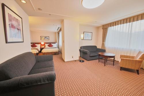 御殿场市富士御殿场伦勃朗高级酒店(Rembrandt Premium Fuji Gotenba)的带沙发的客厅和卧室
