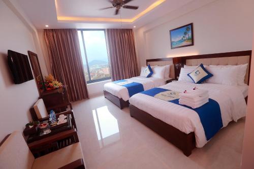 格卢市社Blue Wave Hotel的酒店客房设有两张床和窗户。
