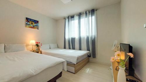 首尔서울아파트 3룸 4베드 Adi Stay的酒店客房设有两张床和电视。