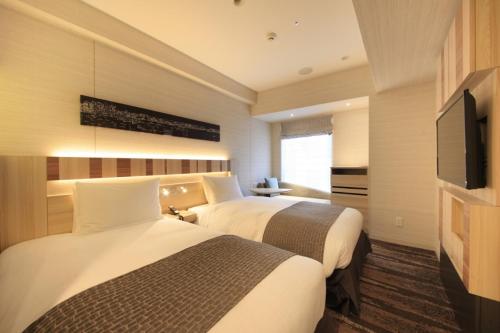 东京银座灿路都大饭店的酒店客房设有两张床和一台平面电视。
