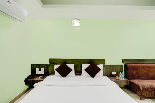 普里Goroomgo Deep Ganga Inn Near Sea Beach Puri的卧室配有一张白色的大床和一张沙发。